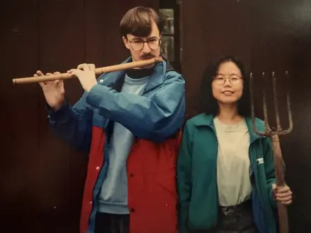 Robert playing a flute beside a friend holding a pitchfork, posed like a farmyard concert.