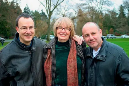 Robert, his sister Jackie and his partner Mitchell in winter coats, arms around each other in Stanley Park, 2008.
